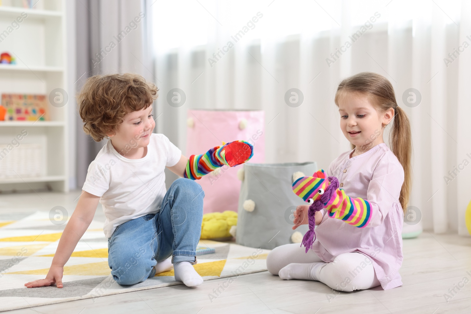 Photo of Cute little children playing with funny sock puppets in kindergarten