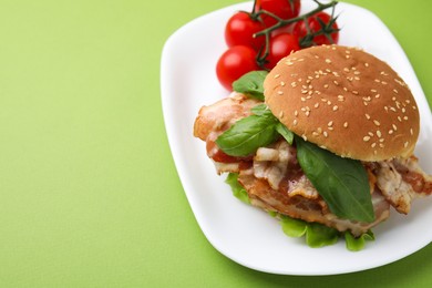 Delicious burger with bacon, basil and tomatoes green table. Space for text