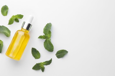 Photo of Bottle of essential oil and mint isolated on white, top view