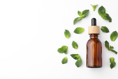 Photo of Bottle of essential oil and mint isolated on white, top view