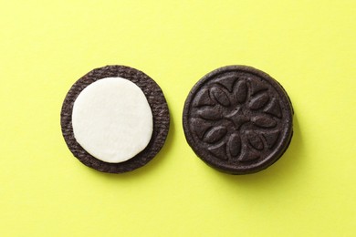 Photo of Tasty sandwich cookies with cream on green background, top view