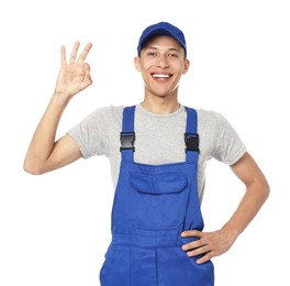 Smiling auto mechanic showing ok gesture on white background