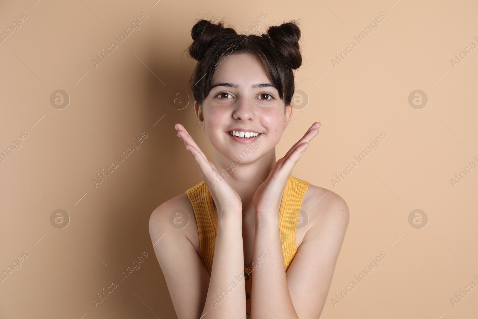 Photo of Portrait of smiling teenage girl on beige background