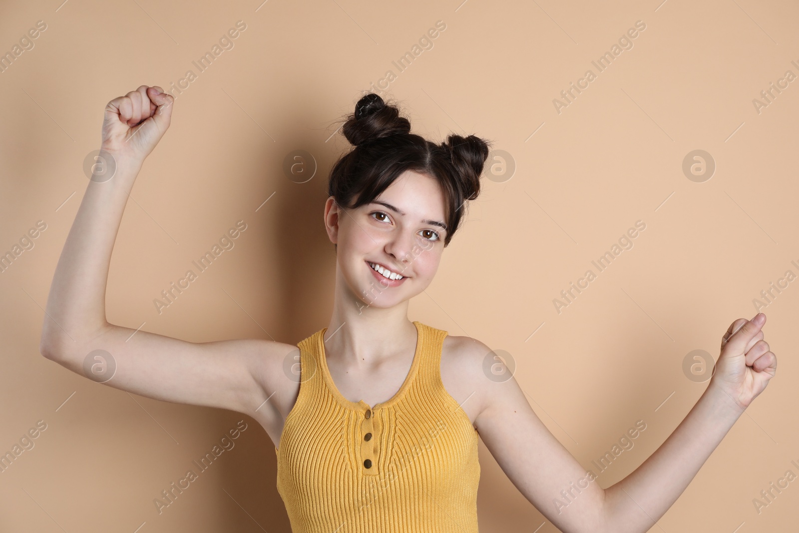 Photo of Portrait of smiling teenage girl on beige background