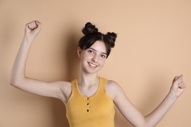 Portrait of smiling teenage girl on beige background