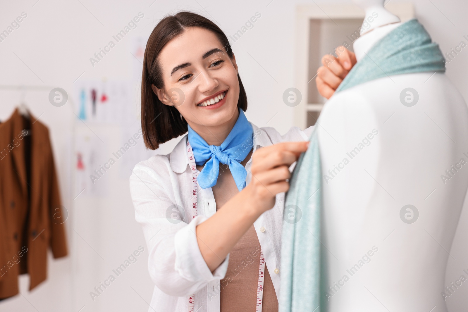 Photo of Fashion designer working with mannequin in workshop