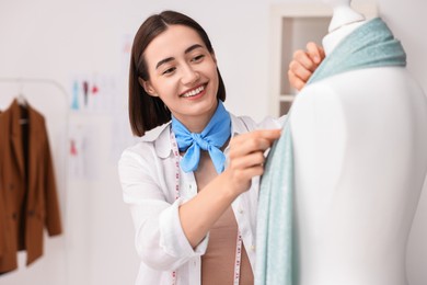 Fashion designer working with mannequin in workshop