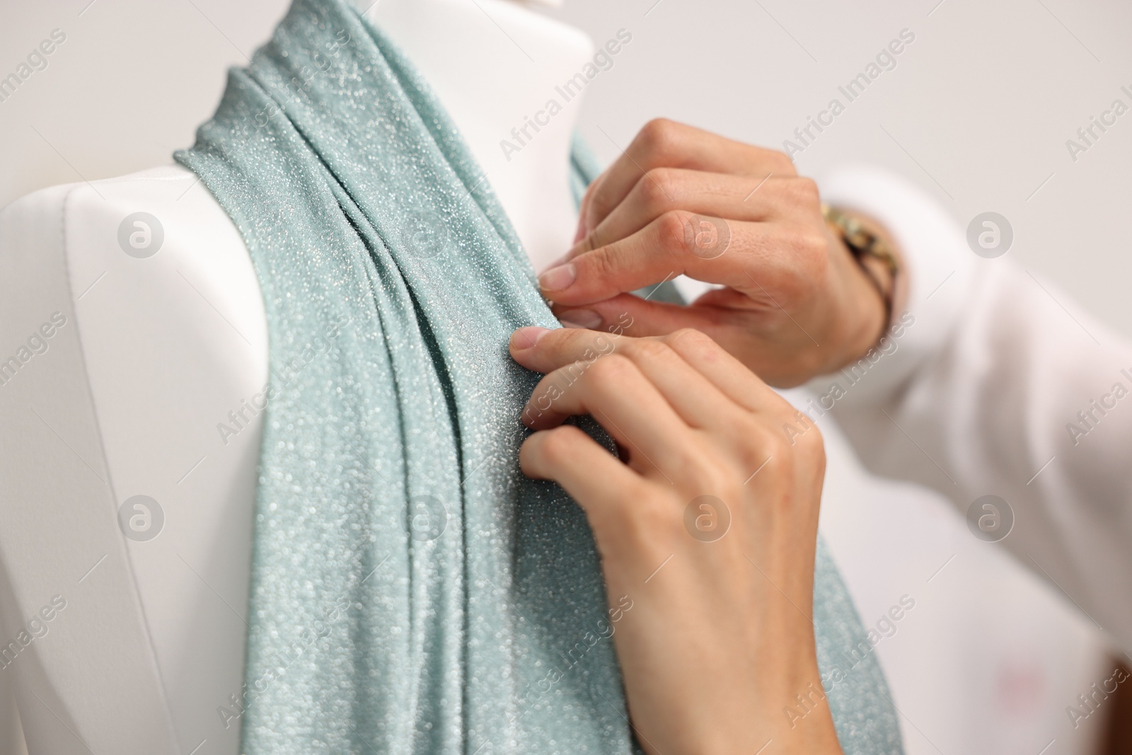 Photo of Fashion designer working with mannequin in workshop, closeup