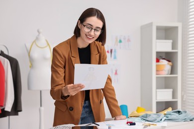 Fashion designer with sketch at table in workshop