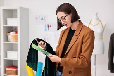 Photo of Fashion designer with color palettes and fabric in workshop