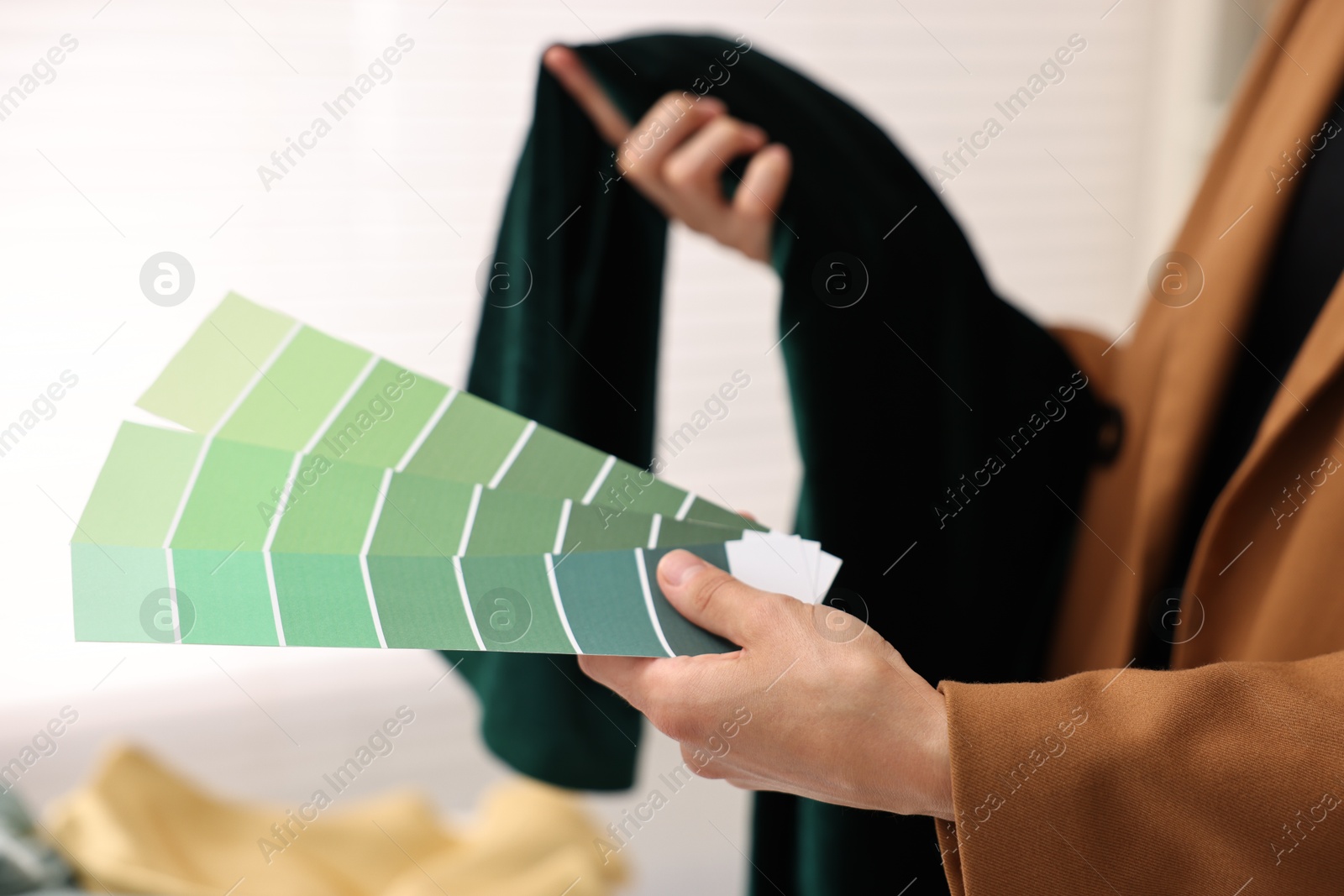 Photo of Fashion designer with color palettes and fabric in workshop, closeup