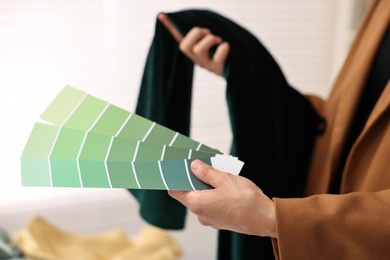 Photo of Fashion designer with color palettes and fabric in workshop, closeup