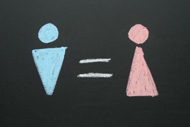 Gender equality concept. Male and female figures drawn on chalkboard, top view