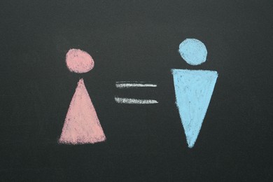 Gender equality concept. Male and female figures drawn on chalkboard, top view