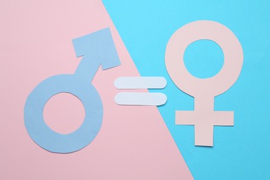 Photo of Equals sign between female and male gender symbols on color background, flat lay