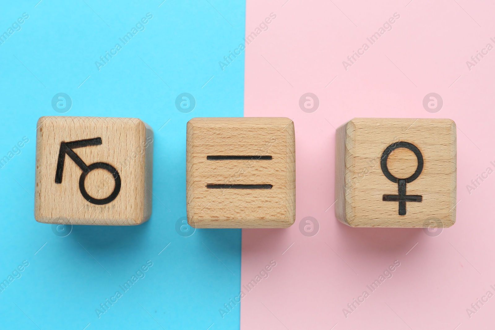 Photo of Gender equality concept. Wooden cubes with male and female symbols on color background, flat lay