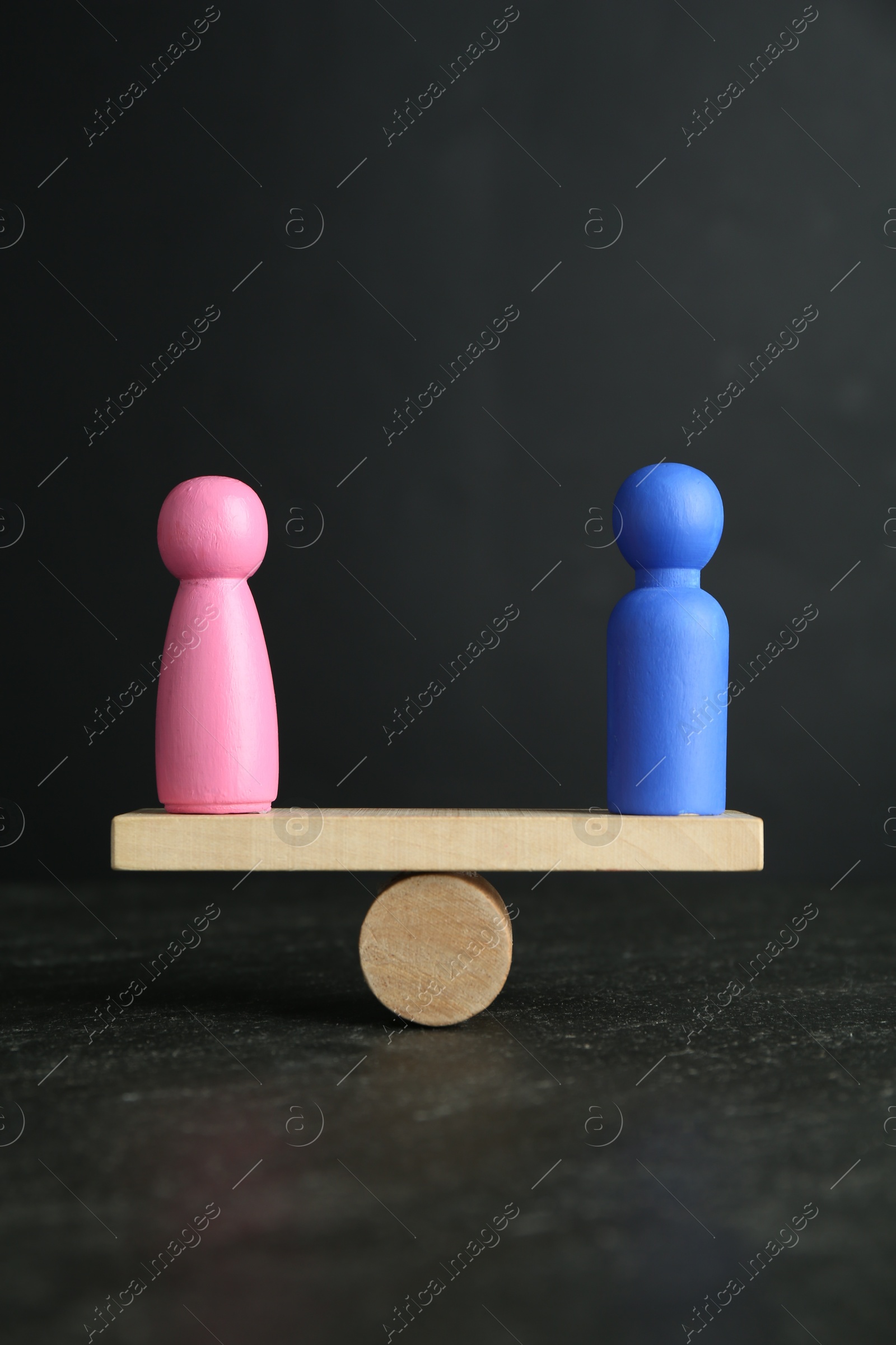 Photo of Gender equality concept. Male and female figures on scales against grey background