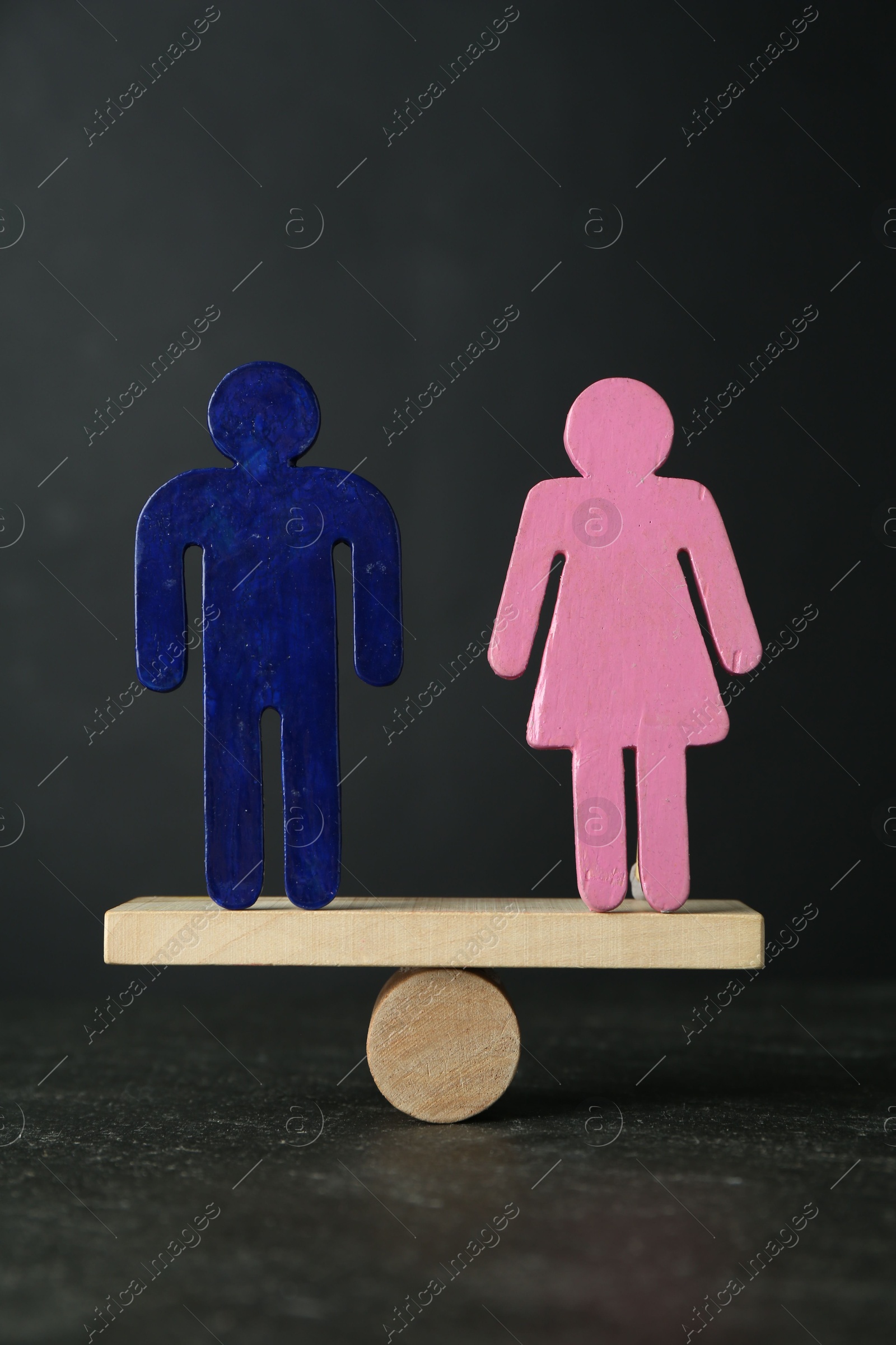 Photo of Gender equality concept. Male and female figures on scales against grey background