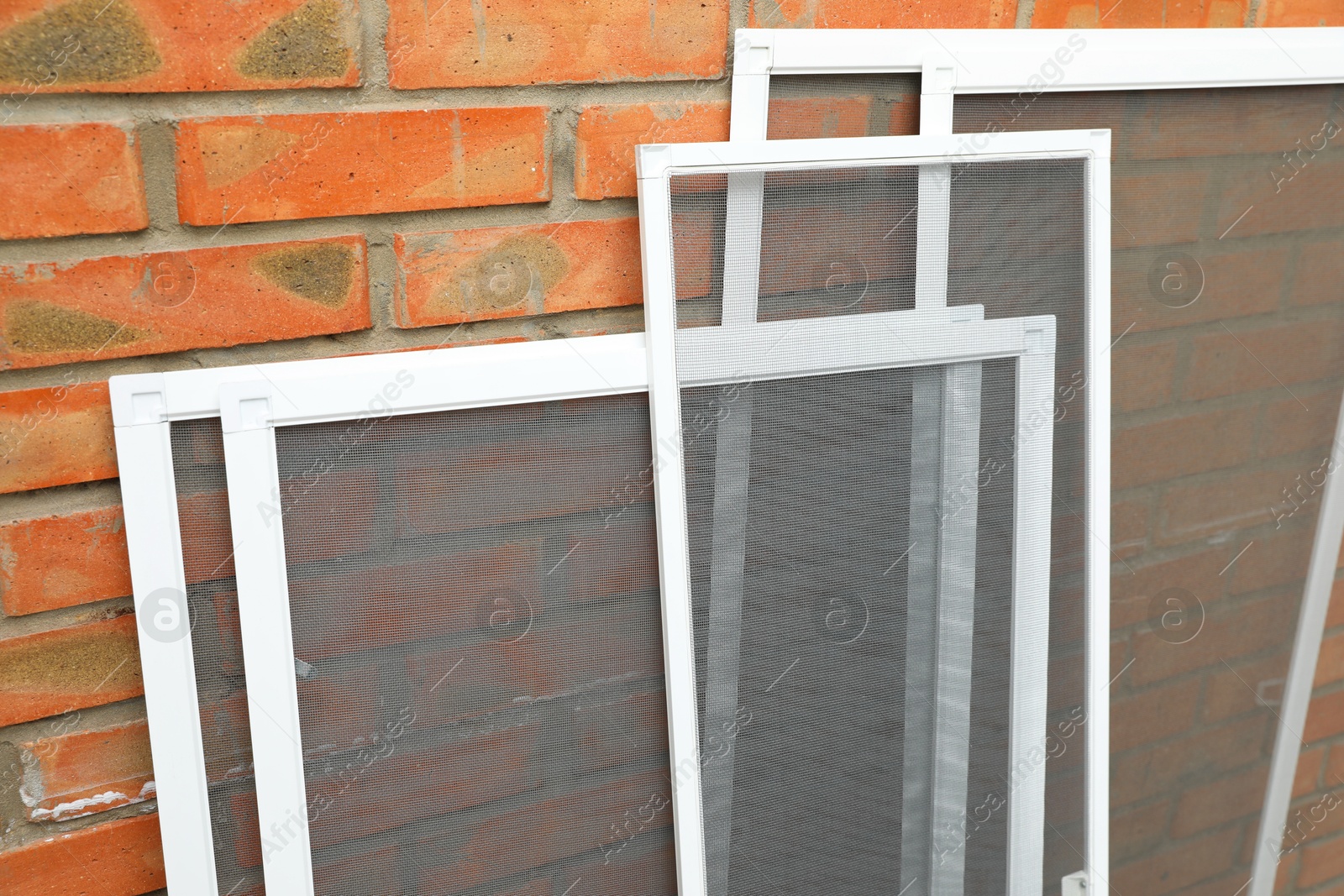 Photo of Set of window screens near brick wall