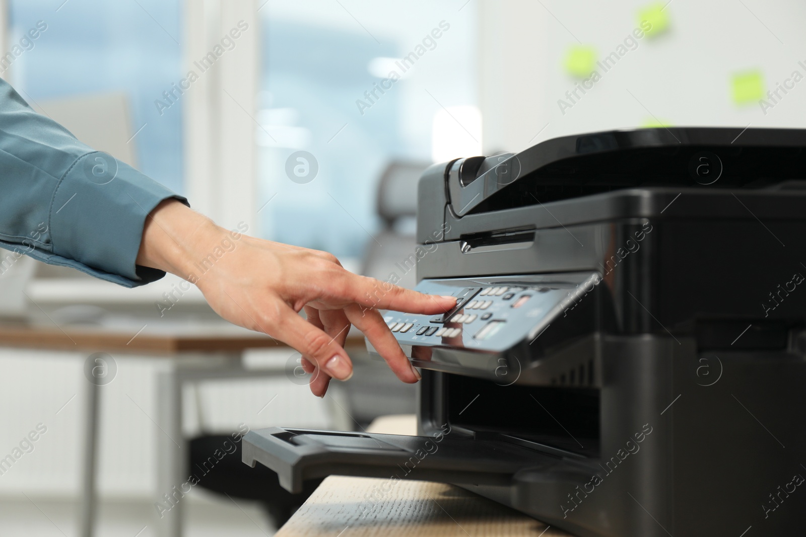 Photo of Woman using modern printer at workplace indoors, closeup