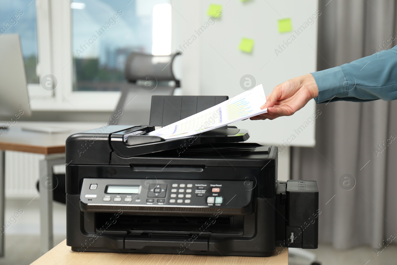 Photo of Woman using modern printer at workplace indoors, closeup