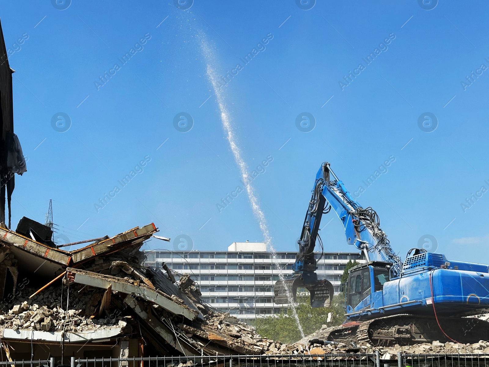 Photo of Demolition of building with excavator under blue sky