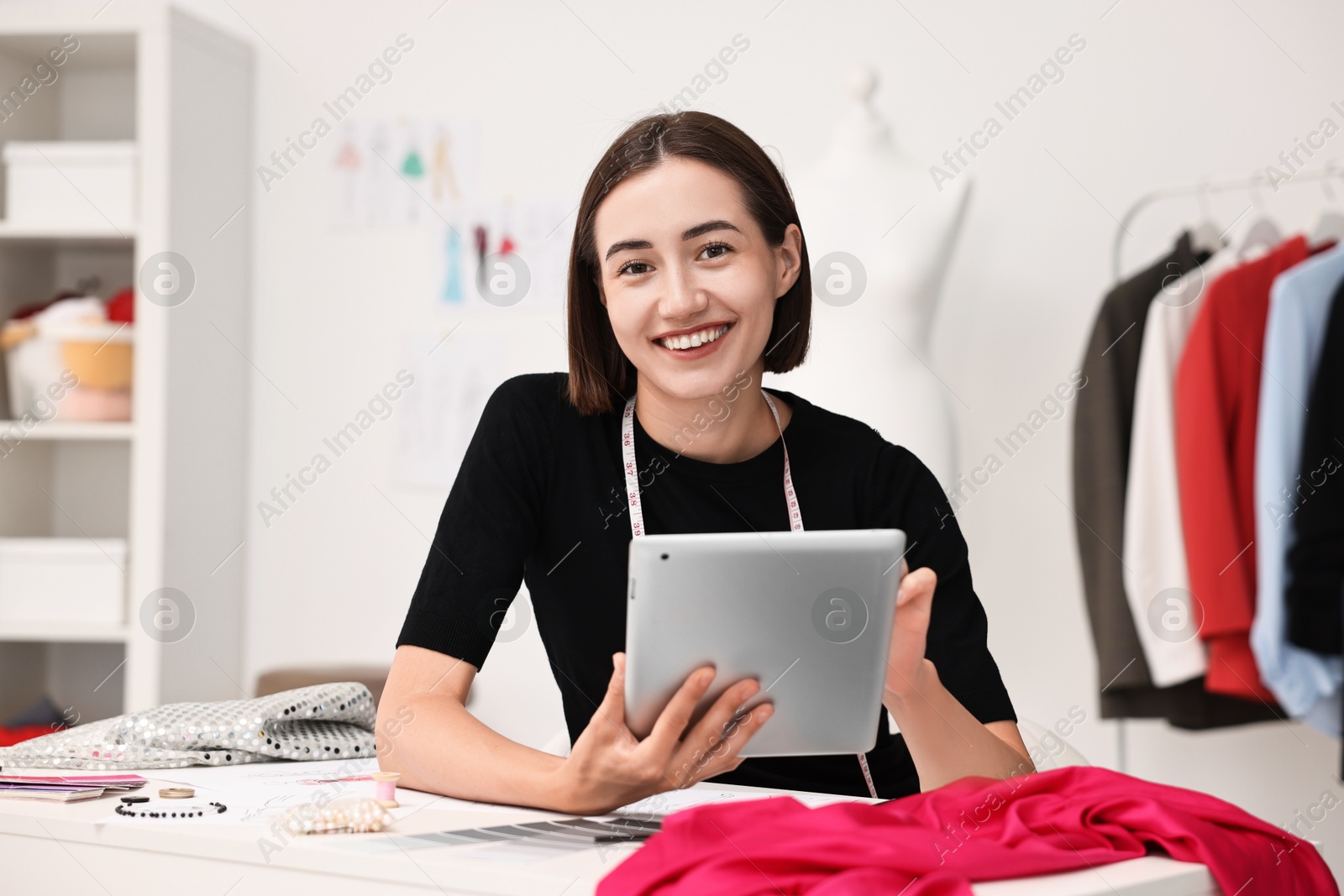 Photo of Fashion designer with tablet working in workshop