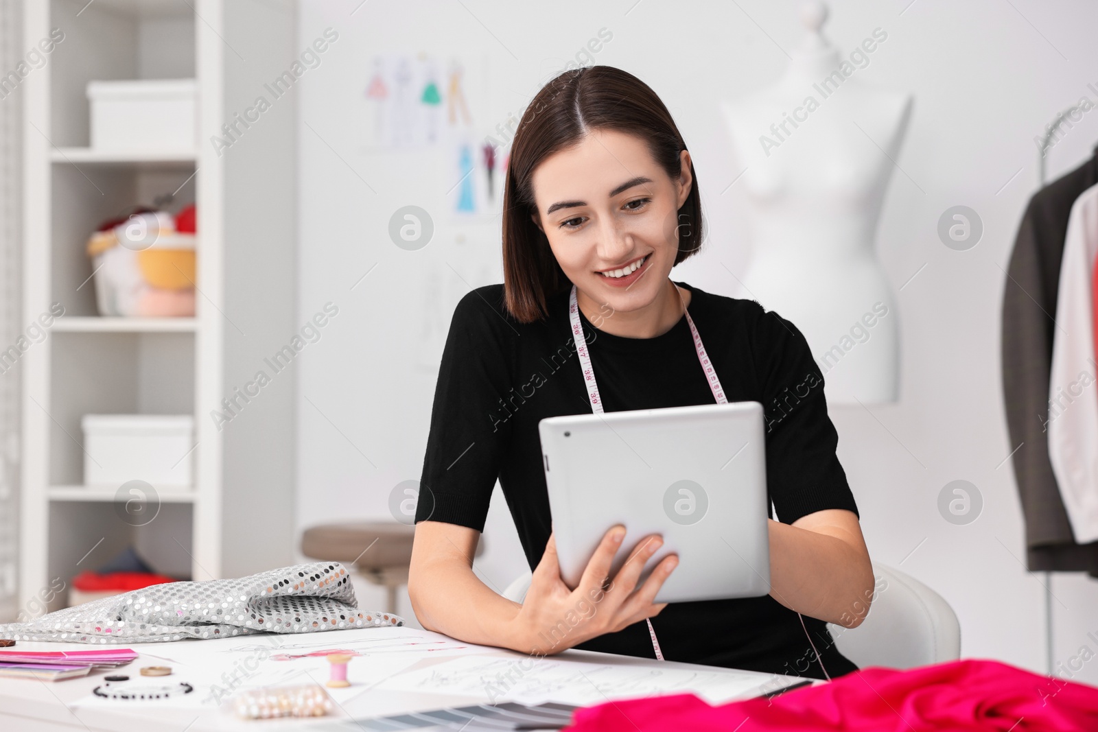 Photo of Fashion designer with tablet working in workshop