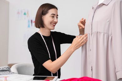 Fashion designer with needles working in workshop