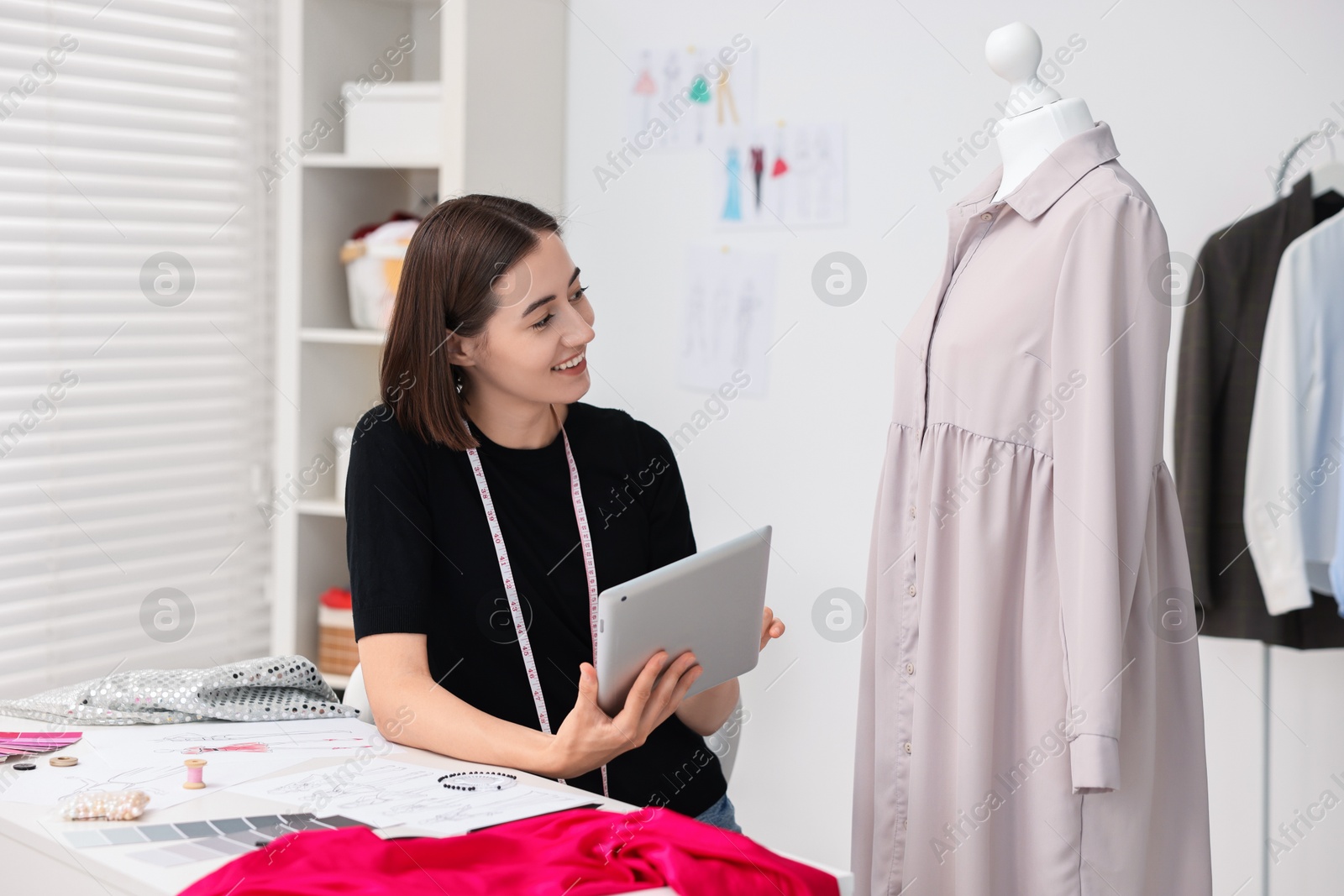 Photo of Fashion designer with tablet working in workshop