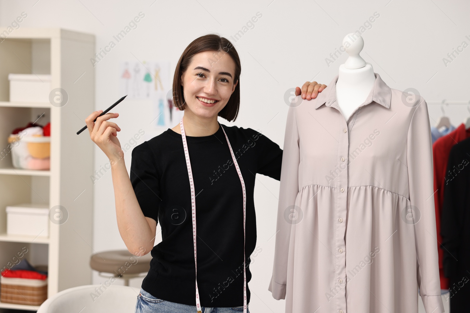 Photo of Fashion designer with beige dress in workshop