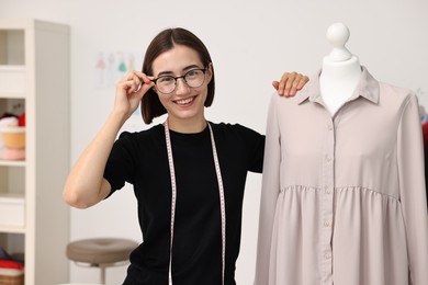 Fashion designer with beige dress in workshop