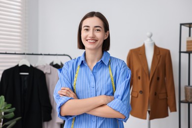 Fashion designer with measuring tape in workshop