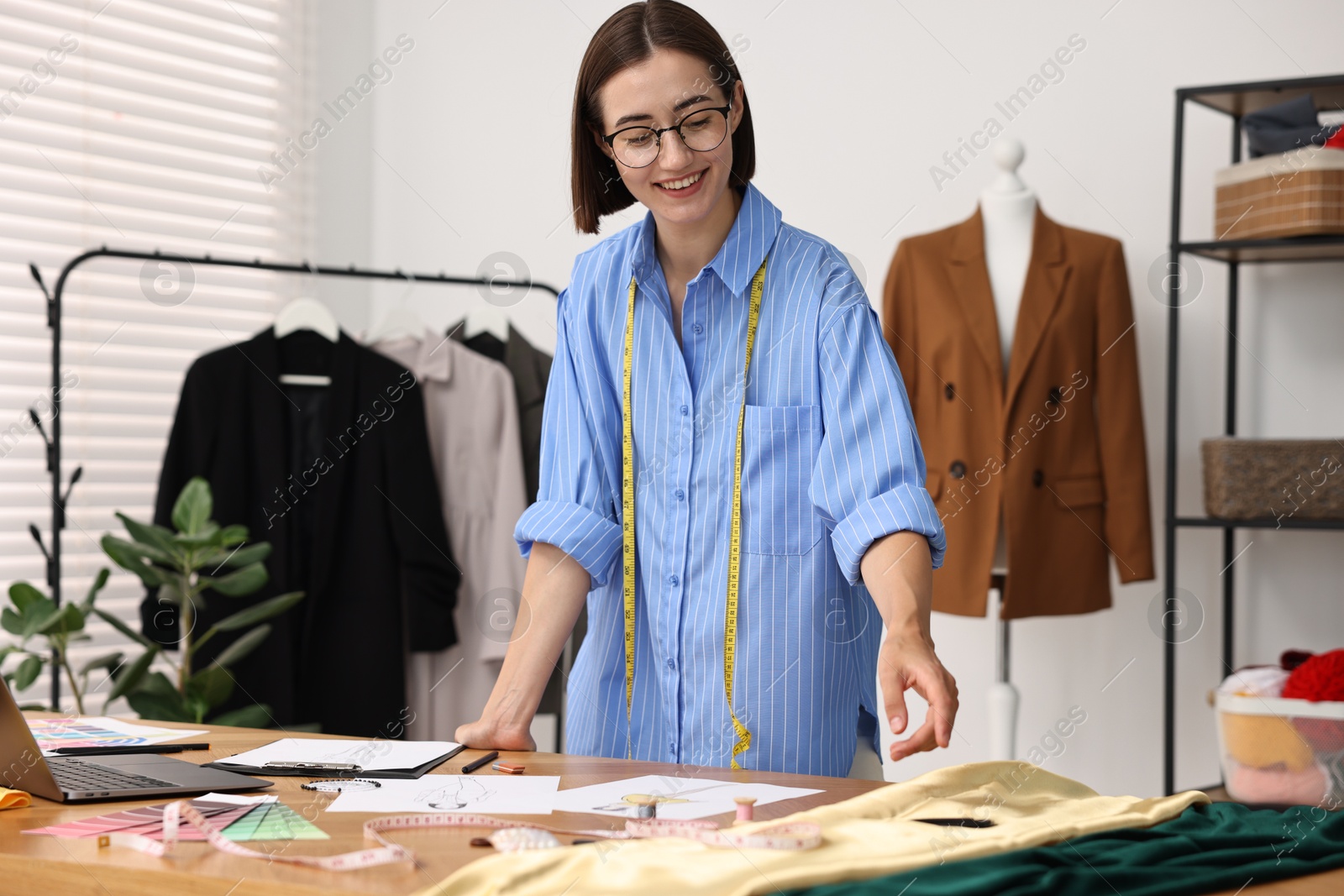 Photo of Fashion designer working at wooden table in workshop