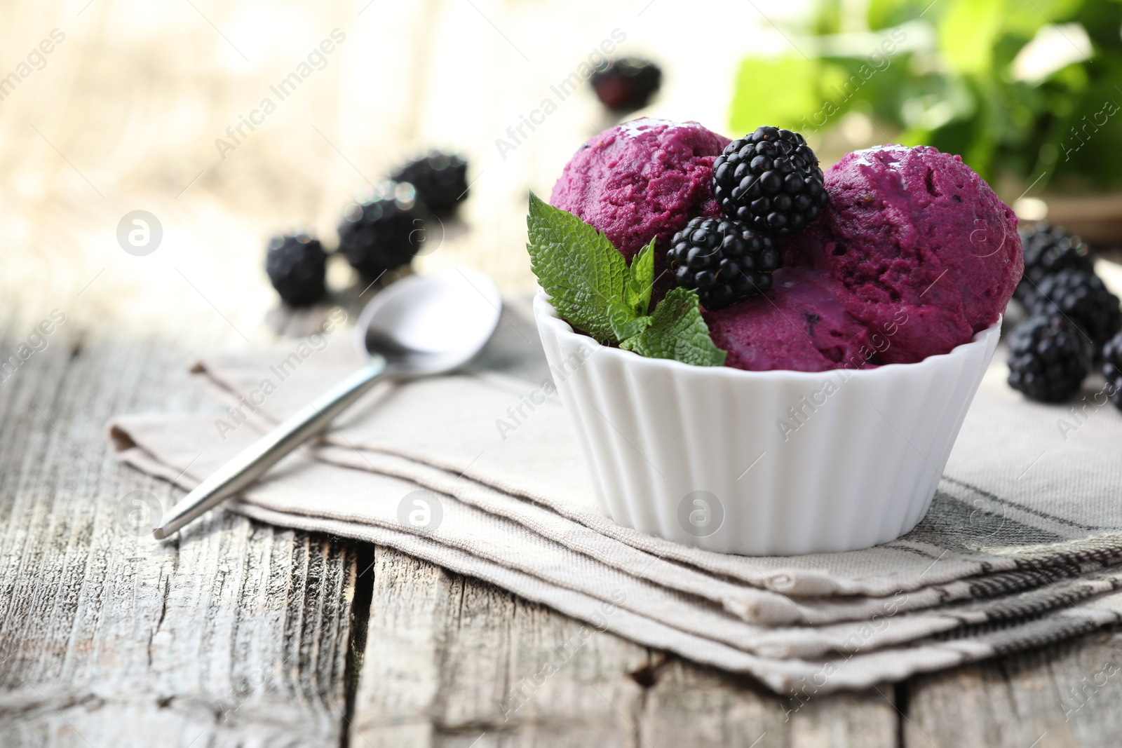 Photo of Delicious blackberry sorbet, mint and fresh berries on wooden table, closeup. Space for text