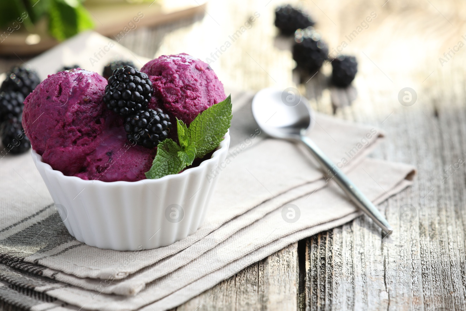 Photo of Delicious blackberry sorbet, mint and fresh berries on wooden table, closeup. Space for text