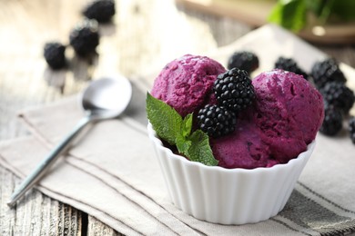 Photo of Delicious blackberry sorbet, mint and fresh berries on wooden table, closeup. Space for text