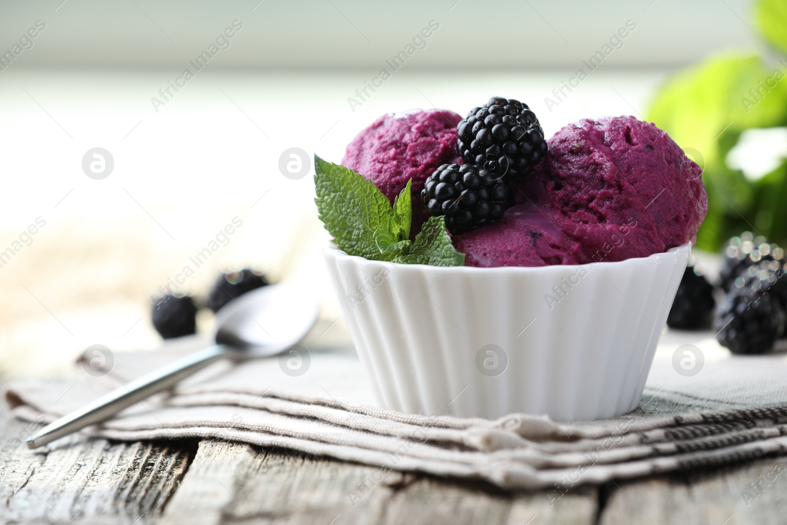 Photo of Delicious blackberry sorbet, mint and fresh berries on wooden table, closeup. Space for text