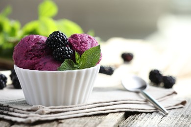 Photo of Delicious blackberry sorbet, mint and fresh berries on wooden table, closeup. Space for text