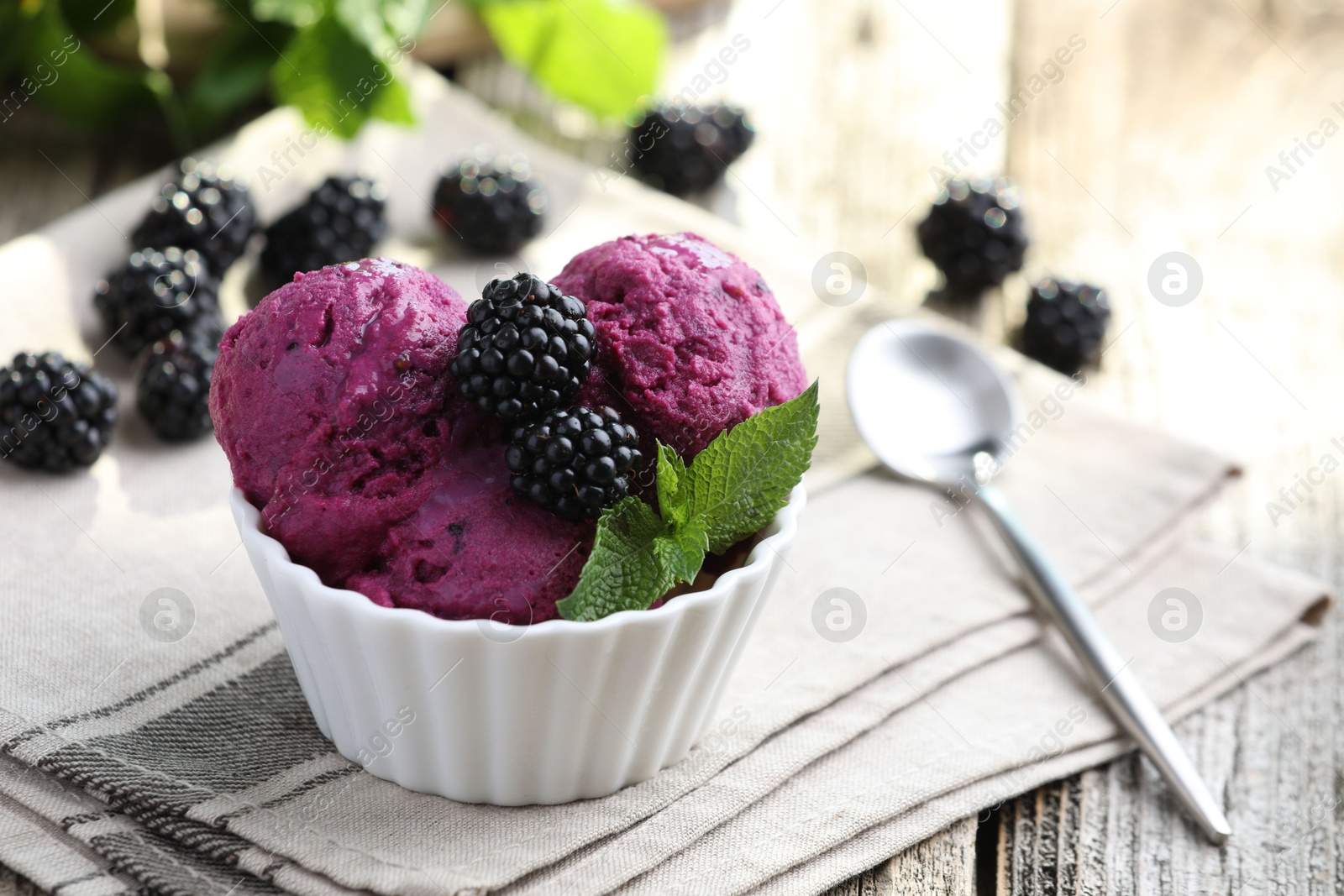 Photo of Delicious blackberry sorbet, mint and fresh berries on wooden table, closeup. Space for text