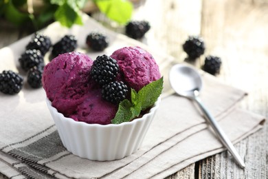 Photo of Delicious blackberry sorbet, mint and fresh berries on wooden table, closeup. Space for text