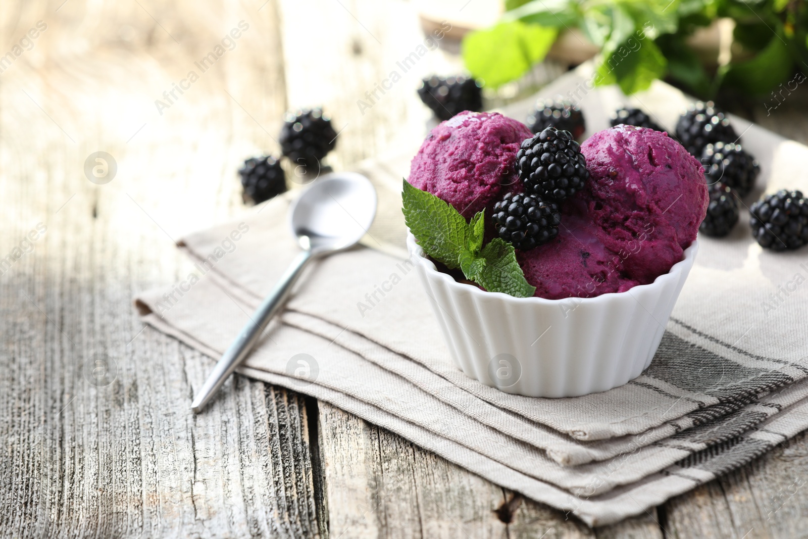 Photo of Delicious blackberry sorbet, mint and fresh berries on wooden table. Space for text