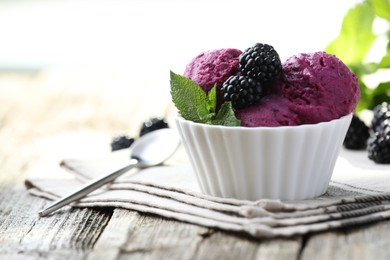 Photo of Delicious blackberry sorbet, mint and fresh berries on wooden table, closeup. Space for text