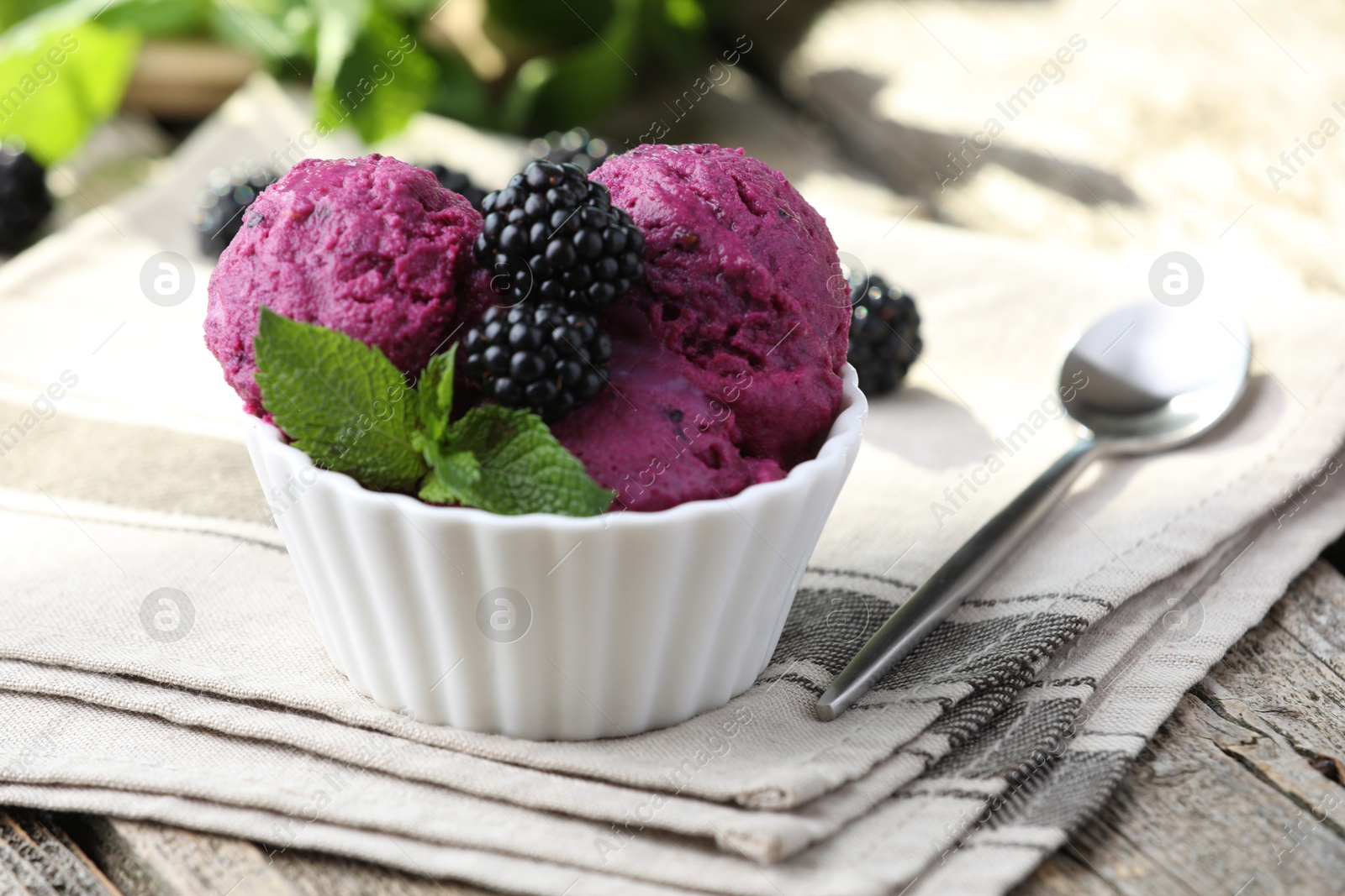 Photo of Delicious blackberry sorbet, mint and fresh berries on wooden table, closeup