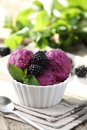 Photo of Delicious blackberry sorbet, mint and fresh berries on wooden table