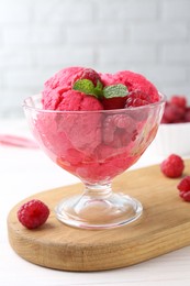 Photo of Delicious raspberry sorbet, mint and fresh berries on white wooden table, closeup