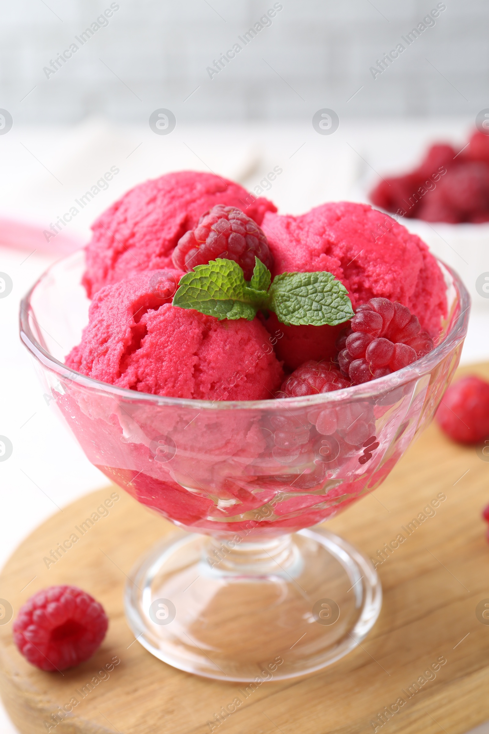 Photo of Delicious raspberry sorbet, mint and fresh berries on white wooden table, closeup