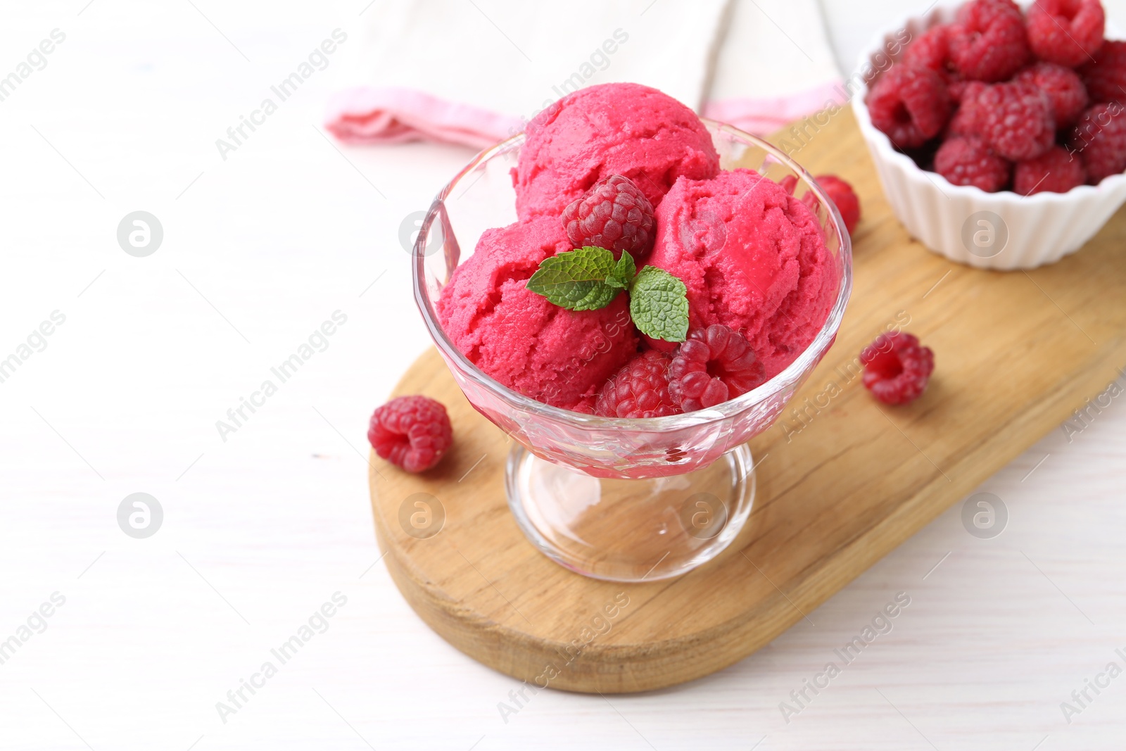 Photo of Delicious raspberry sorbet, mint and fresh berries on white wooden table, space for text