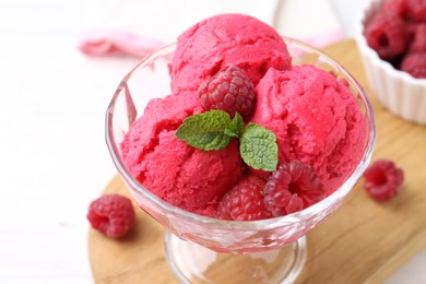 Photo of Delicious raspberry sorbet, mint and fresh berries on white wooden table, closeup