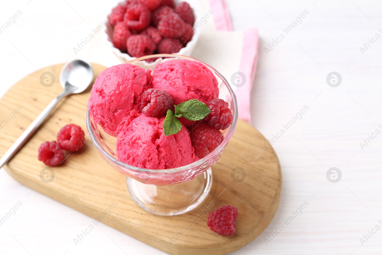 Photo of Delicious raspberry sorbet, mint and fresh berries on white wooden table, space for text